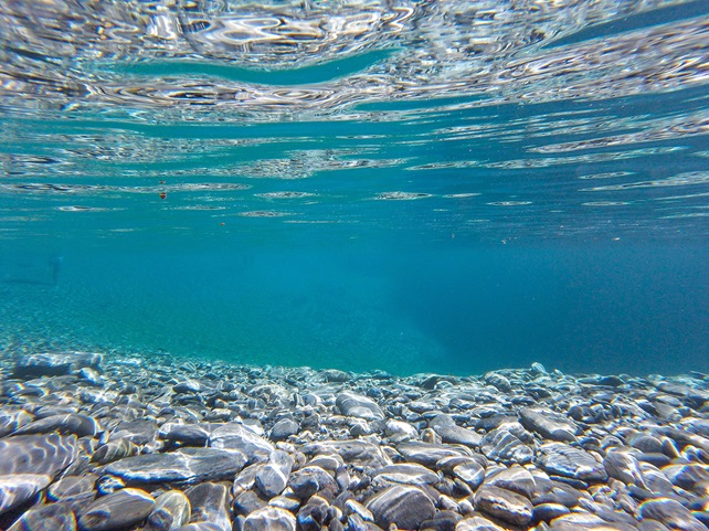 Under blue ocean with floor rocks