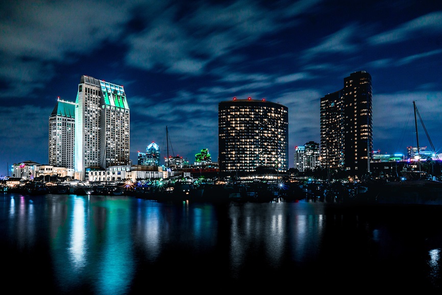 Calm ocean at night overlooking the lights of the San Diego skyline.