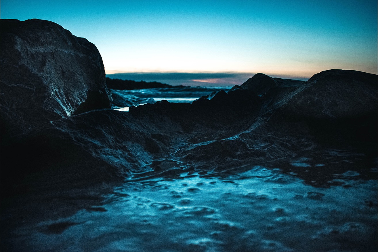 Rocky ocean with foam at sunset