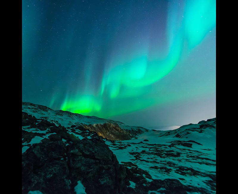 Aurora borealis with snow covered ground
