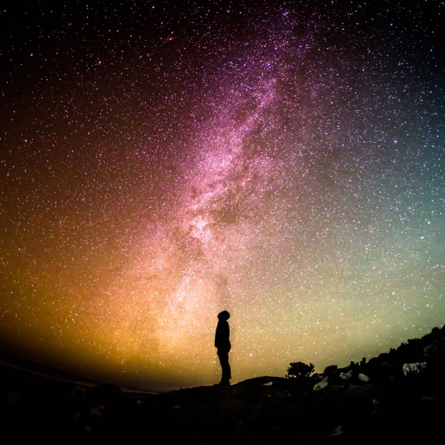 Silhouette person looking into the galaxy sky