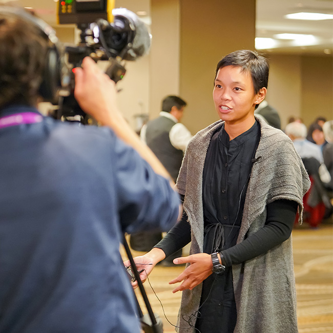 Woman is interviewed  on camera at Fall Meeting