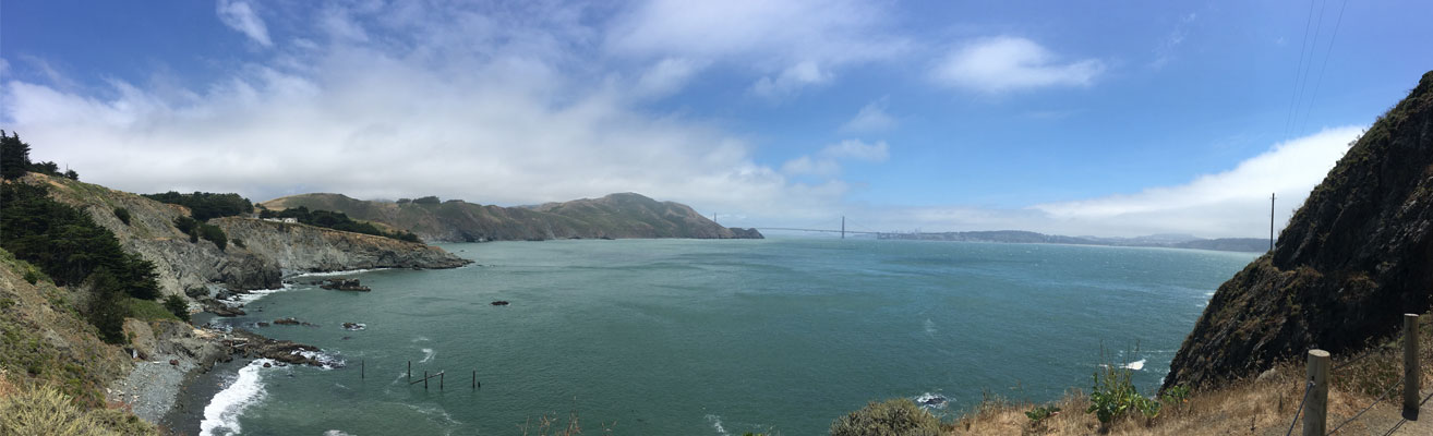 Panoramic view of Bay with hills and Golden Gate Bridge in the distance