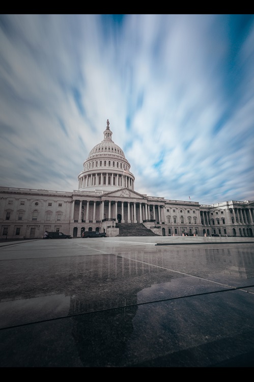 Capitol building with clouds and reflection