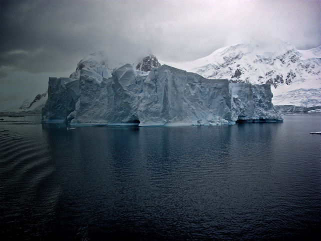 Iceberg with calm water and mountains