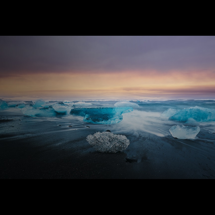 Long exposure of ice on beach at sunset