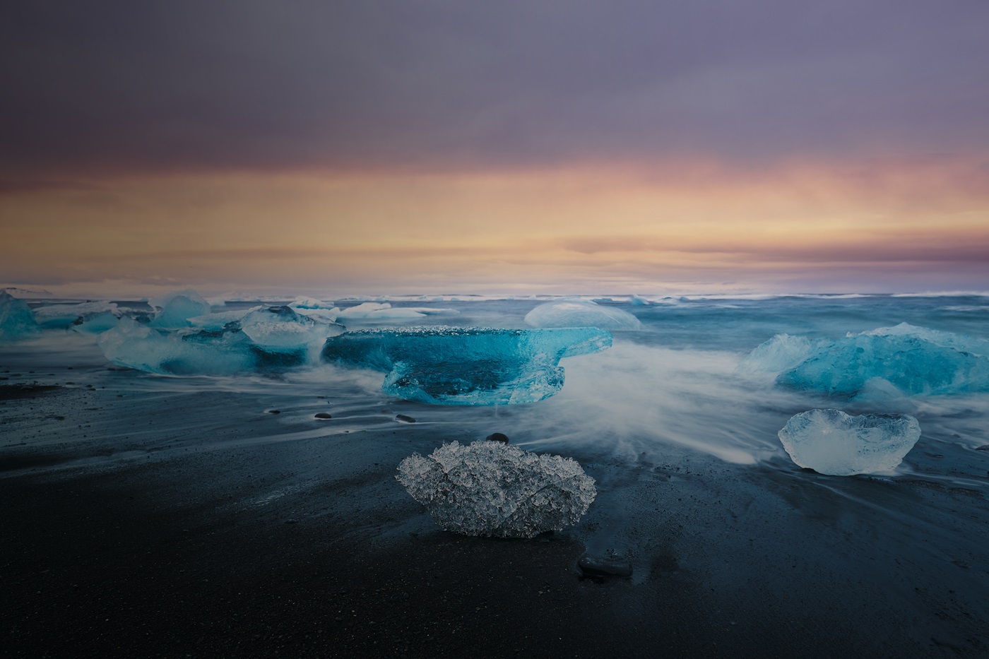 Long exposure of ice on beach at sunset