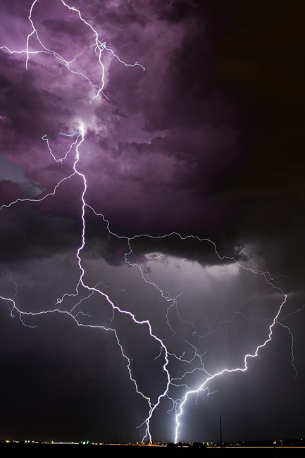 Lightning strikes and storm clouds over a city