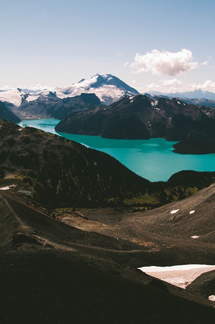 Teal lake with mountains in background