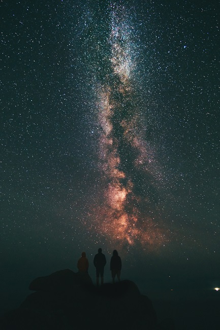 People silhouetted against the night sky with star