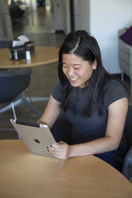 Woman smiling while holding ipad in office