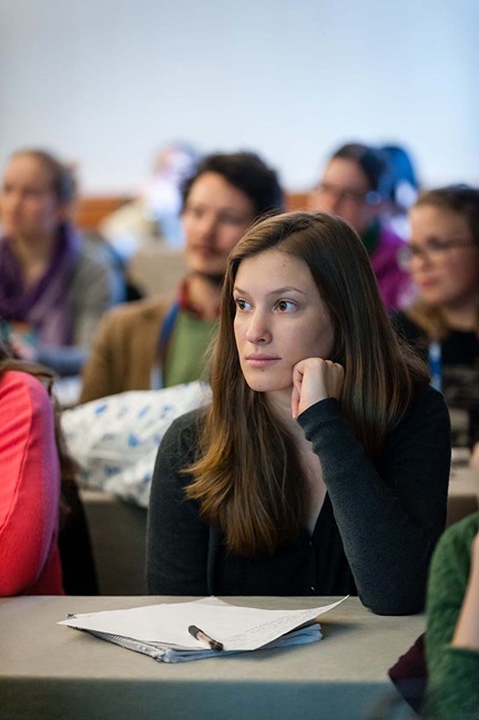 Student listening in class with pen and paper on desk